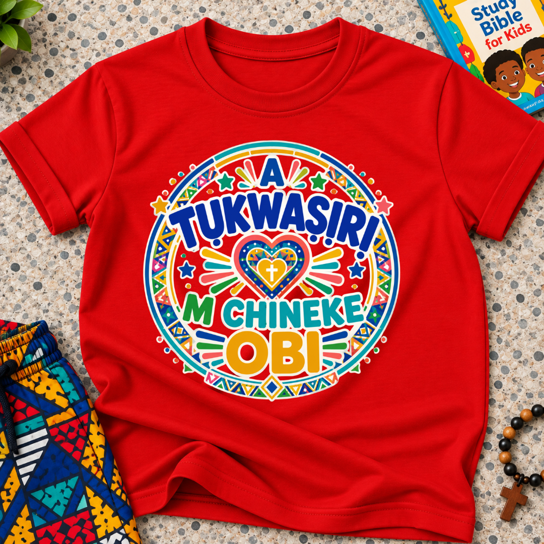 A Tukwasiri M Chineke Obi Igbo-language kids shirt in red featuring colourful lettering, a heart motif, and circular decorative patterns
