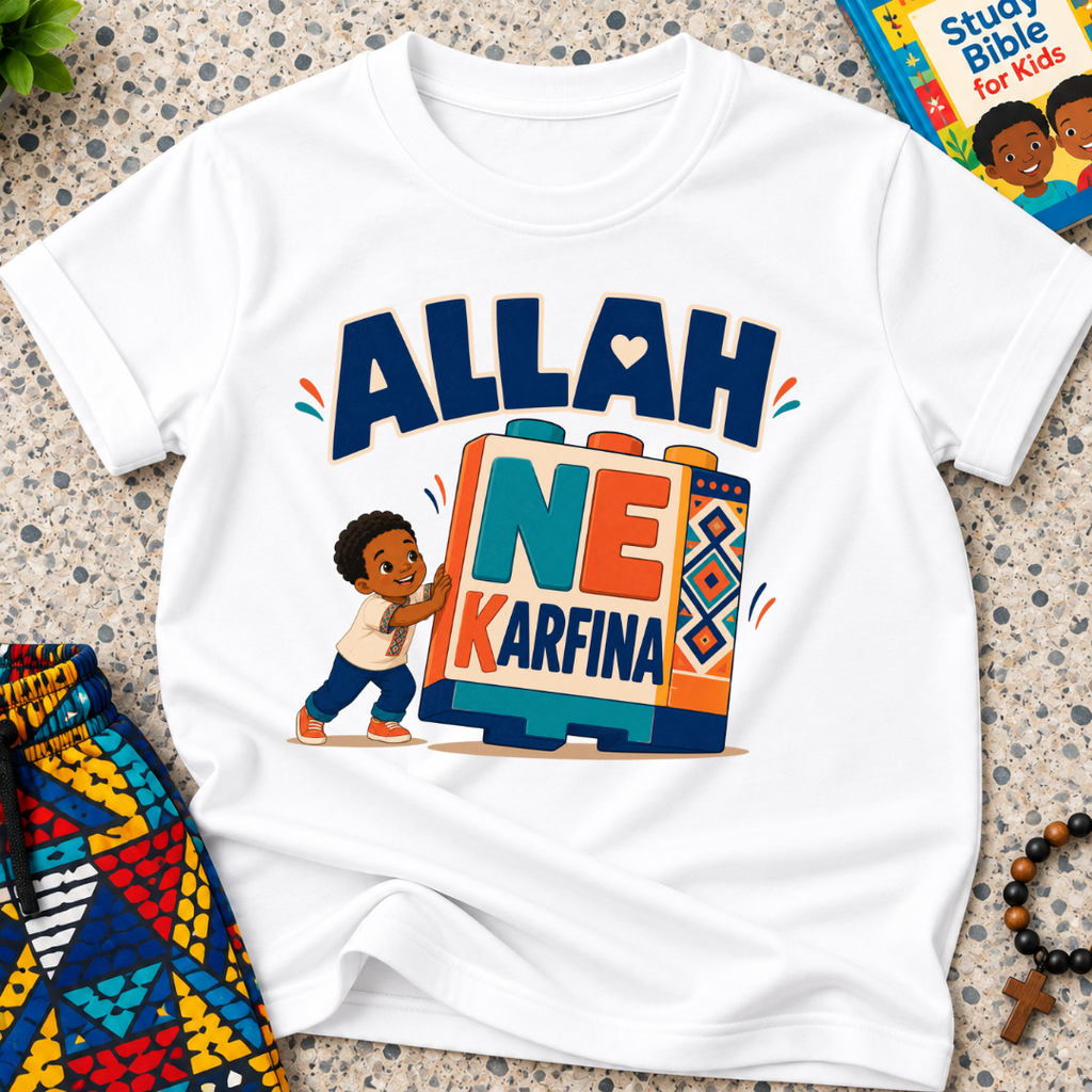 Allah Ne Ƙarfina Hausa-language kids shirt in white featuring bold lettering and a child beside colourful blocks
