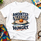 Anointed Blessed Still Hungry Christian kids shirt in white featuring bold lettering and food-inspired artwork
