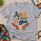 Anụ Ni mo ri Gba kids shirt in grey featuring colourful lettering, raised hands, and decorative artwork
