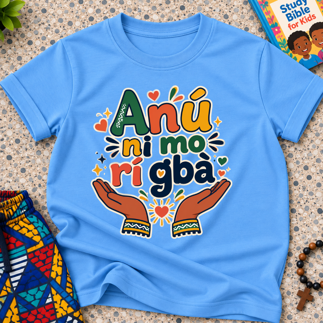 Anụ Ni mo ri Gba kids shirt in light blue featuring colourful lettering, raised hands, and decorative artwork
