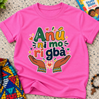 Anụ Ni mo ri Gba kids shirt in pink featuring colourful lettering, raised hands, and decorative artwork
