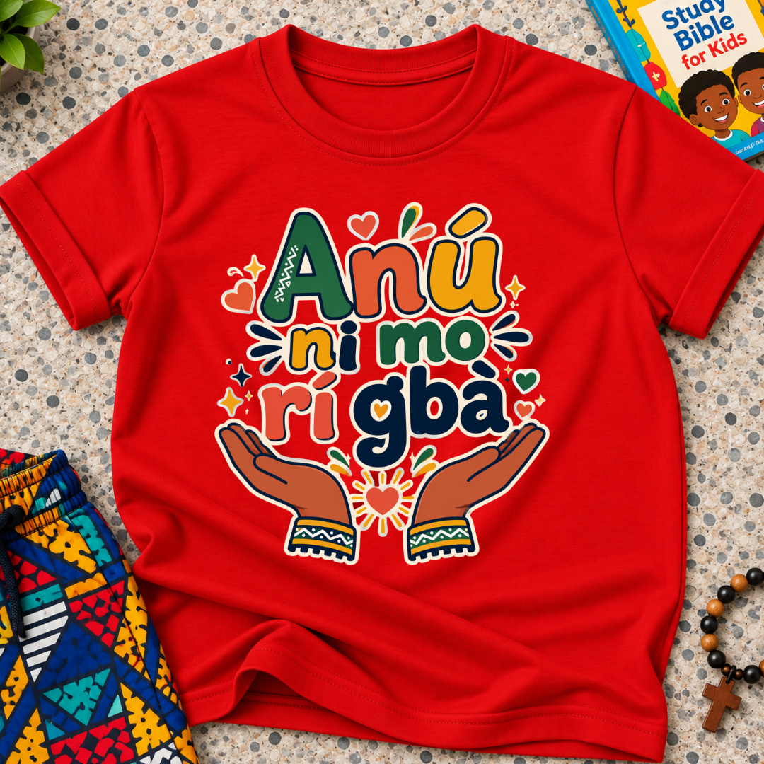 Anụ Ni mo ri Gba kids shirt in red featuring colourful lettering, raised hands, and decorative artwork
