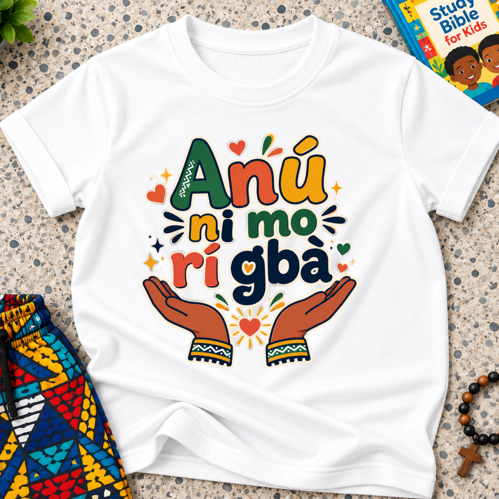 Anụ Ni mo ri Gba kids shirt in white featuring colourful lettering, raised hands, and decorative artwork

