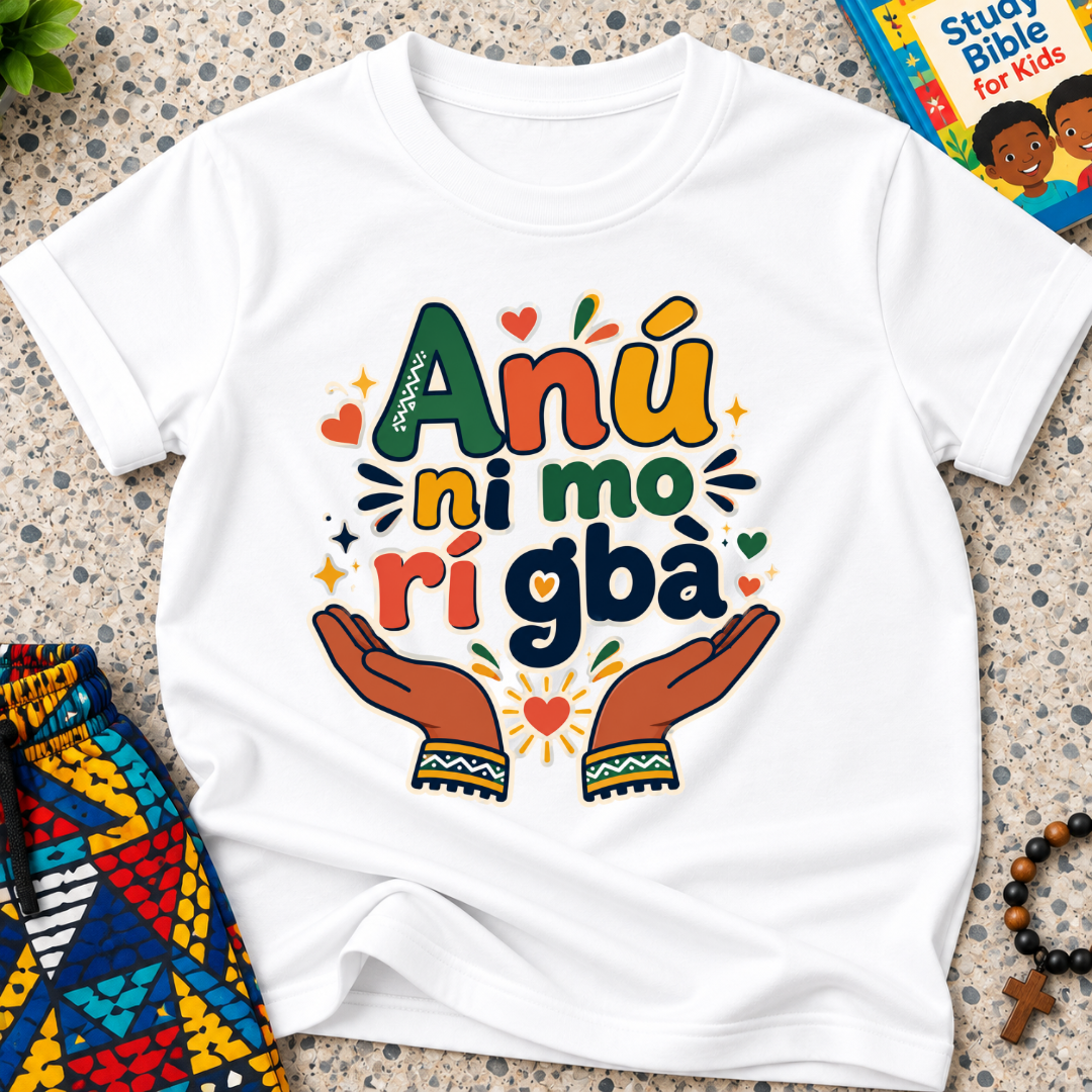 Anụ Ni mo ri Gba kids shirt in white featuring colourful lettering, raised hands, and decorative artwork
