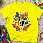 Anụ Ni mo ri Gba kids shirt in yellow featuring colourful lettering, raised hands, and decorative artwork

