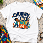 Chukwu Bụ Ike M Igbo Christian kids shirt in white featuring bold lettering and a child beside colourful blocks
