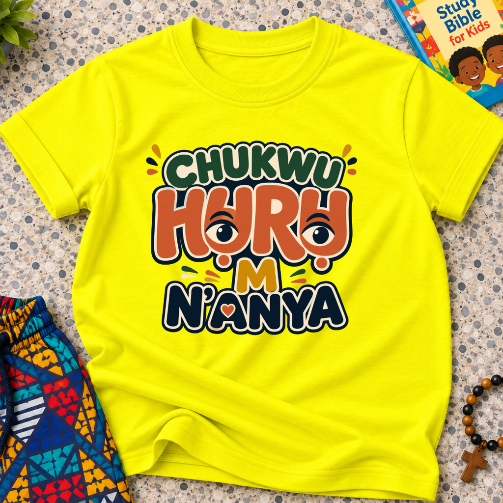 Chukwu Huru M N'anya Igbo Christian kids shirt in yellow featuring bold colourful lettering and decorative artwork
