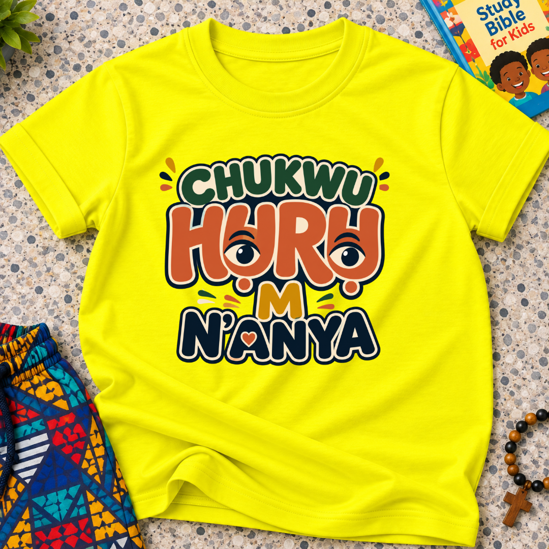 Chukwu Huru M N'anya Igbo Christian kids shirt in yellow featuring bold colourful lettering and decorative artwork
