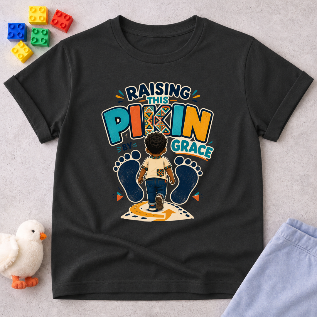 Raising This Pikin by Grace Christian kids shirt in black featuring a child illustration and playful Nigerian parenting message
